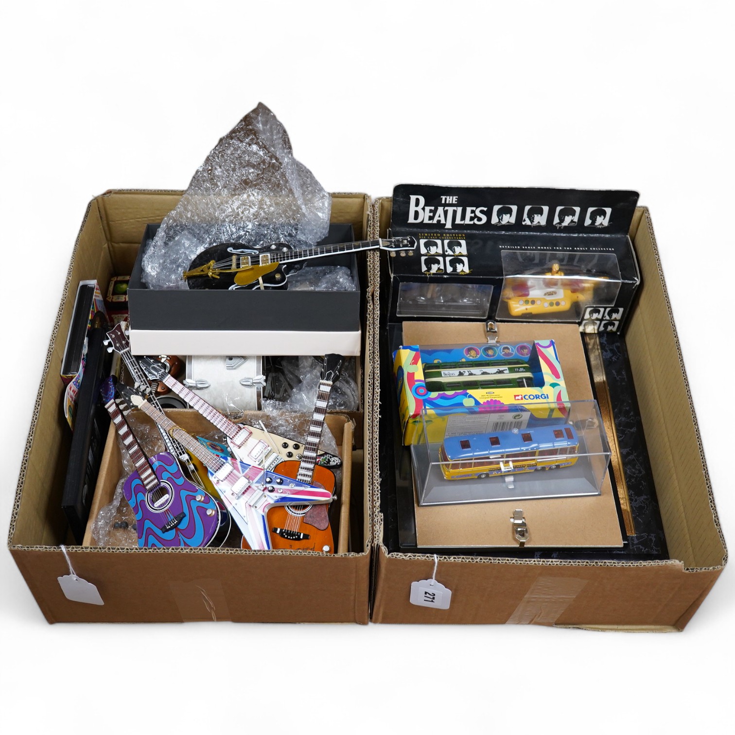 A collection of Beatles memorabilia including; models of a Beatles drum kit and eight miniature guitars and stands, each approx 25cm long, together with three boxed Corgi Beatles related models, including the Yellow Subm